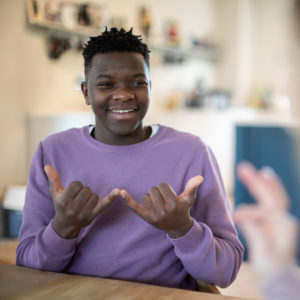 Teenage Boy And Girl Having Conversation Using Sign Language